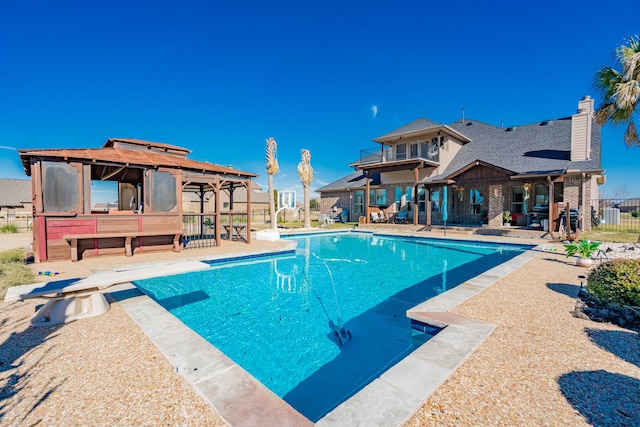 view of swimming pool with a diving board and a patio area