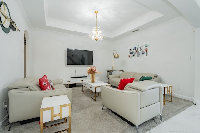 living room featuring crown molding, a tray ceiling, and a chandelier