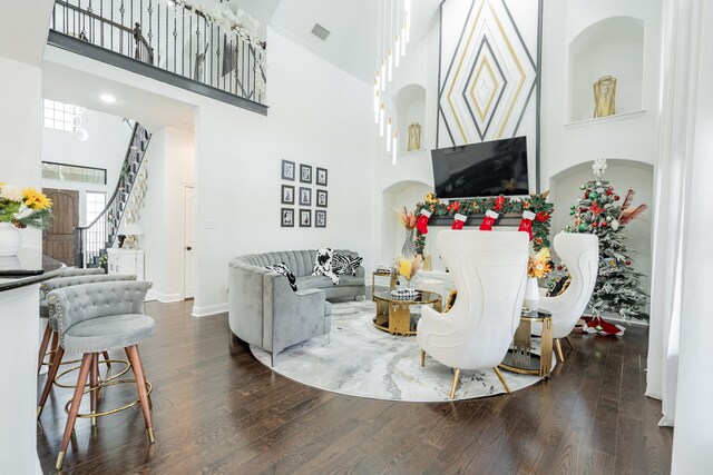 living room featuring dark hardwood / wood-style flooring and a towering ceiling