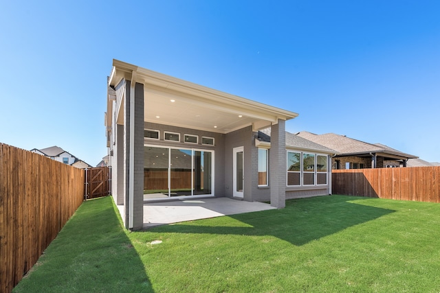 back of house featuring a lawn and a patio