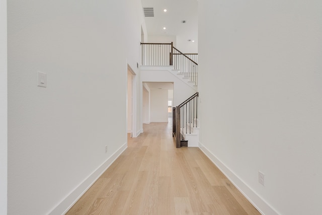 interior space with a high ceiling and light hardwood / wood-style flooring