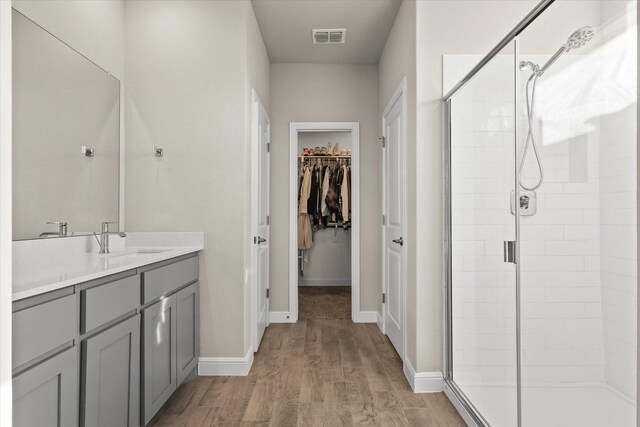 bathroom featuring hardwood / wood-style floors, vanity, and walk in shower