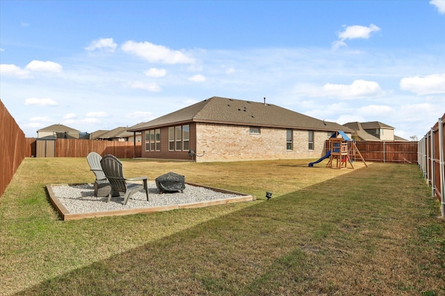 rear view of house featuring a lawn and a playground