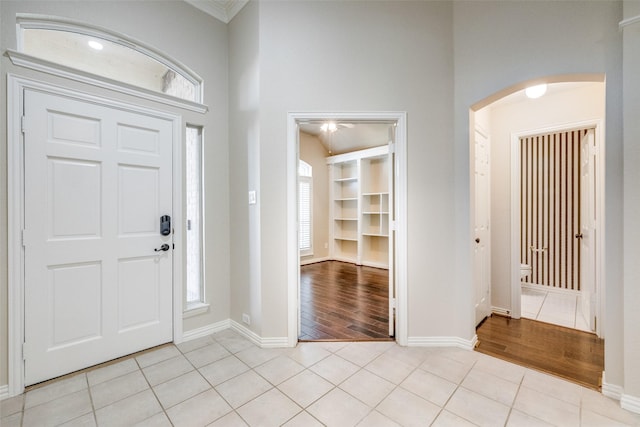 entrance foyer with crown molding and light hardwood / wood-style flooring