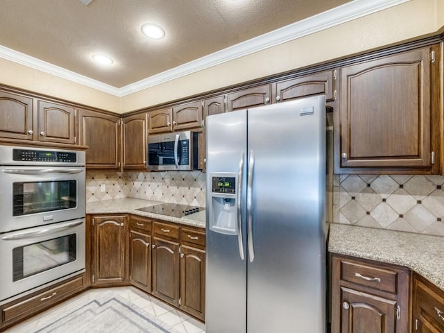 kitchen featuring crown molding, stainless steel appliances, light stone countertops, and decorative backsplash