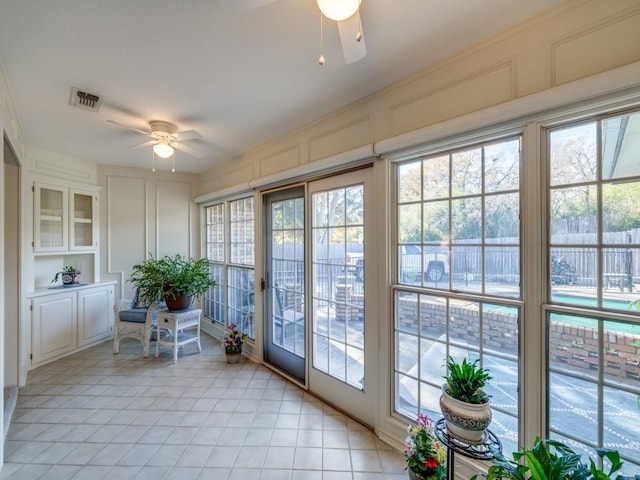 unfurnished sunroom featuring ceiling fan