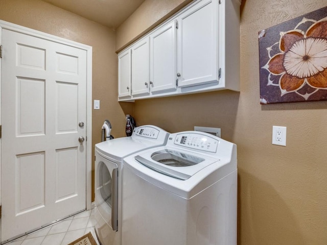 washroom with cabinets, light tile patterned flooring, and washer and dryer