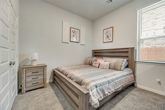 bedroom featuring multiple windows and light carpet