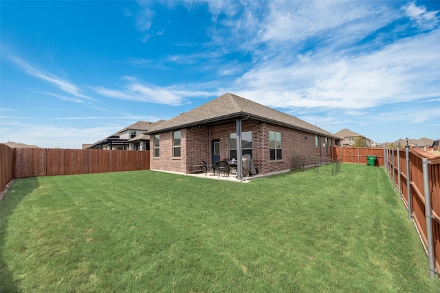 back of house featuring a patio area and a lawn