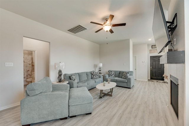 living room with ceiling fan and light hardwood / wood-style flooring