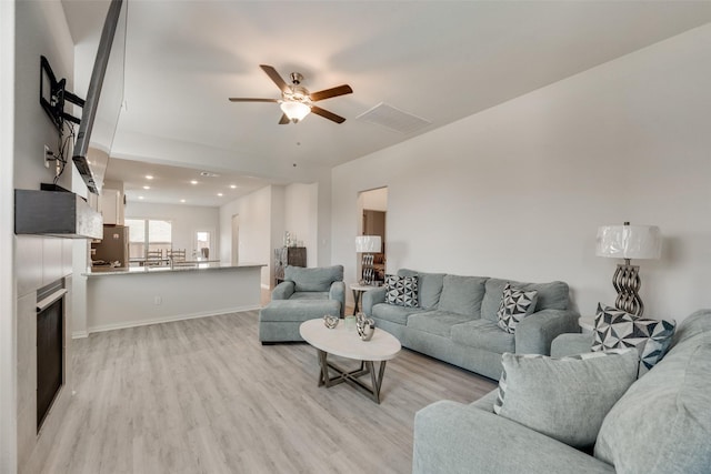 living room featuring ceiling fan and light hardwood / wood-style floors