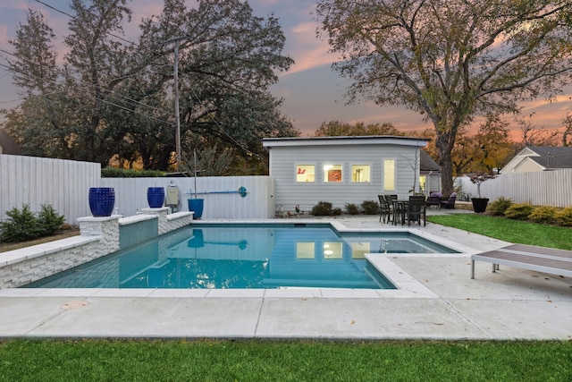 pool at dusk with a patio