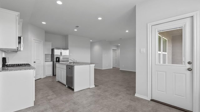 kitchen featuring a kitchen island with sink, sink, white cabinets, and appliances with stainless steel finishes