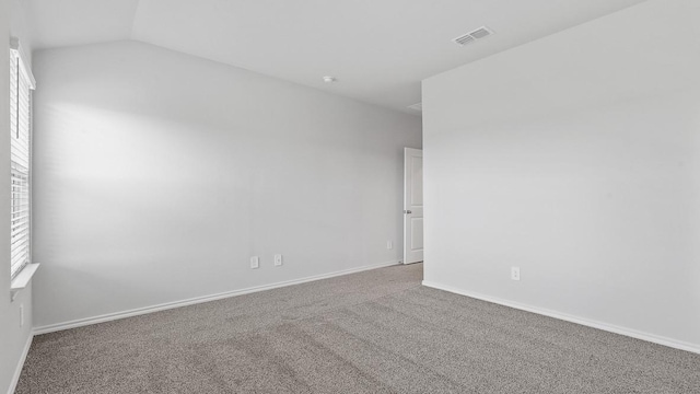 empty room with carpet and vaulted ceiling