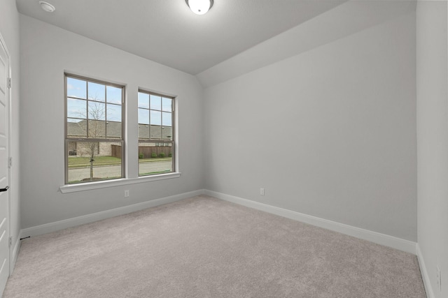 unfurnished room with baseboards, light colored carpet, and vaulted ceiling