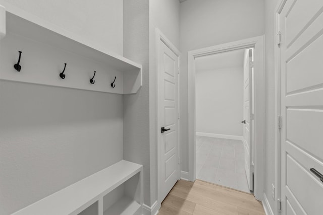 mudroom with light wood finished floors and baseboards