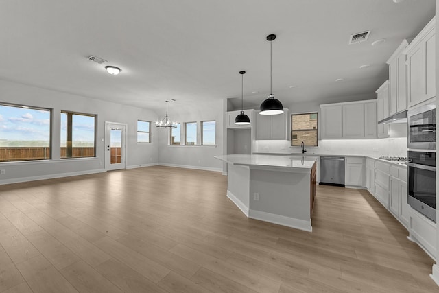 kitchen with a chandelier, tasteful backsplash, visible vents, and appliances with stainless steel finishes