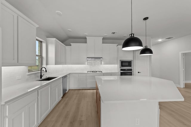 kitchen featuring visible vents, a center island, a sink, and appliances with stainless steel finishes