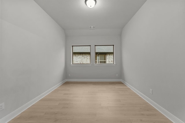 spare room with light wood-type flooring, baseboards, and visible vents