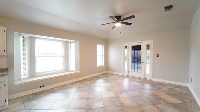 tiled empty room featuring ceiling fan