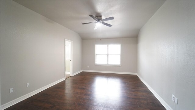 spare room with dark hardwood / wood-style flooring, vaulted ceiling, and ceiling fan