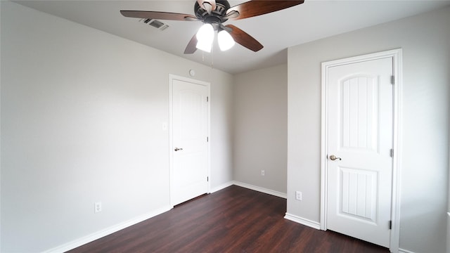 unfurnished bedroom with ceiling fan and dark wood-type flooring