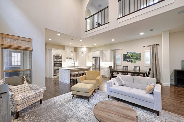 living room with dark wood-type flooring and a high ceiling