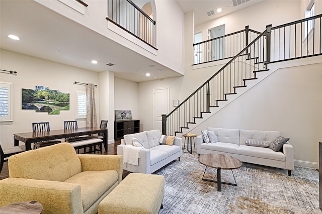 living room with a towering ceiling and hardwood / wood-style flooring