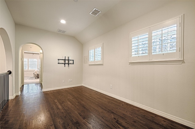 empty room with dark hardwood / wood-style floors and lofted ceiling