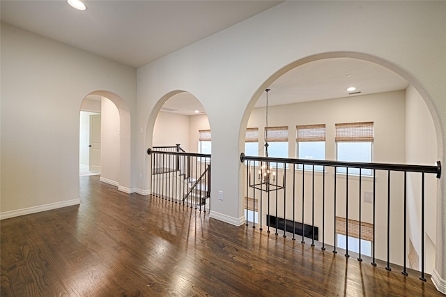 interior space featuring dark hardwood / wood-style floors, an inviting chandelier, and a water view