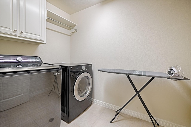 clothes washing area featuring cabinets and washing machine and dryer