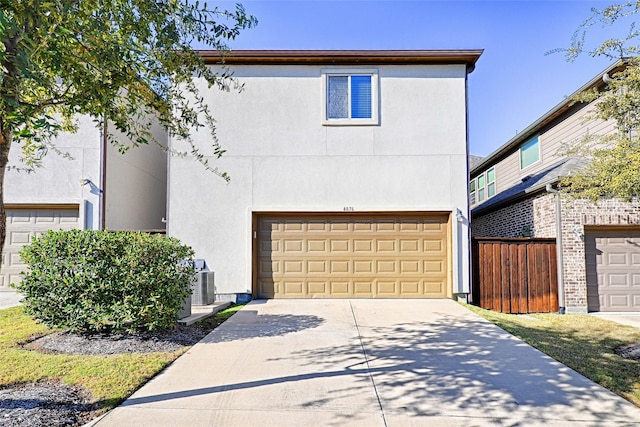 view of front of house with a garage and central air condition unit