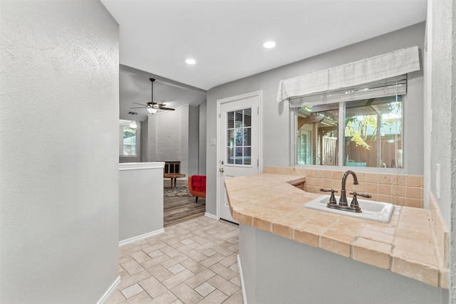 kitchen with plenty of natural light, ceiling fan, sink, and tasteful backsplash