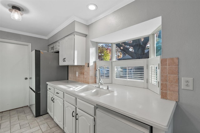 kitchen featuring white cabinetry, sink, tasteful backsplash, stainless steel fridge, and ornamental molding