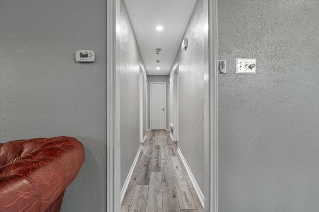 hallway with light hardwood / wood-style floors