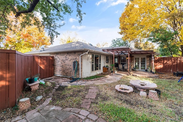 rear view of property featuring a pergola and a patio