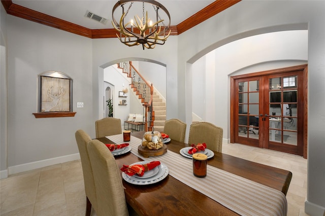 dining room featuring a notable chandelier, visible vents, baseboards, french doors, and ornamental molding