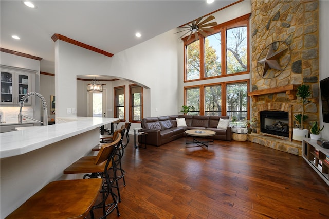 588 Lakepoint Loop, Pottsboro, TX 75076 - living area with ceiling fan, arched walkways, crown molding, a fireplace, and dark wood finished floors