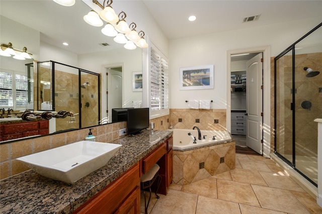 full bathroom featuring a sink, visible vents, a spacious closet, a tub with jets, and a stall shower