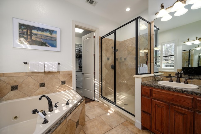 full bathroom with a whirlpool tub, a shower stall, a spacious closet, and visible vents