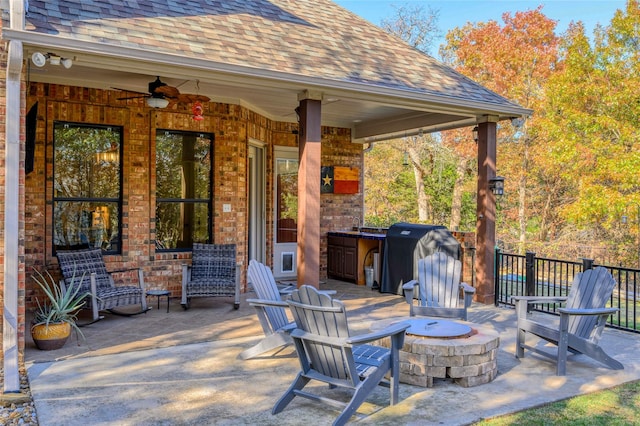 view of patio with an outdoor fire pit, ceiling fan, grilling area, and fence