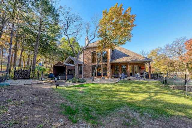 rear view of house featuring a yard, a chimney, a patio area, and fence