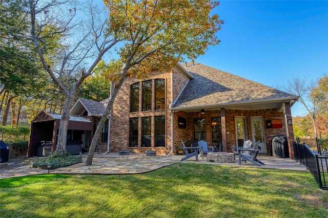 back of house with a fire pit, fence, a yard, roof with shingles, and a patio area