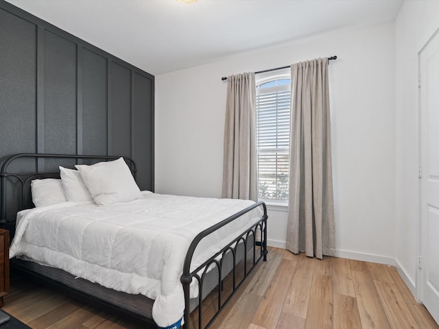 bedroom featuring light hardwood / wood-style flooring and multiple windows