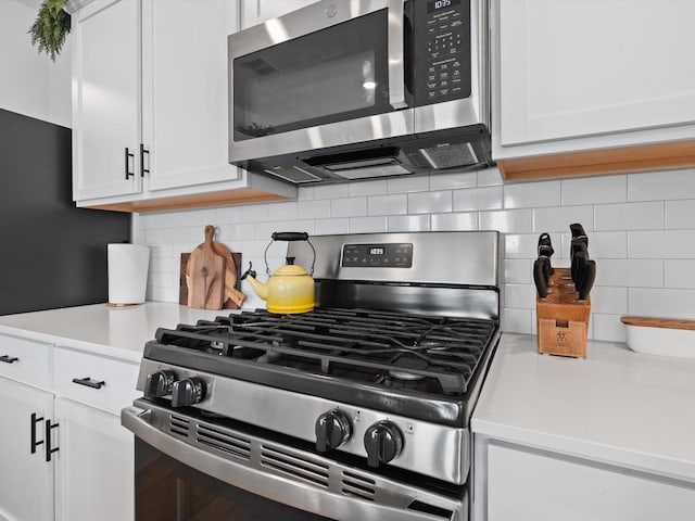 kitchen featuring tasteful backsplash, stainless steel appliances, and white cabinets