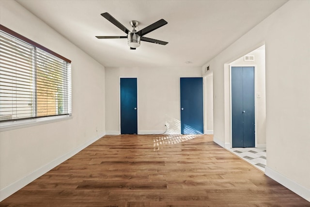 unfurnished room with ceiling fan and hardwood / wood-style flooring