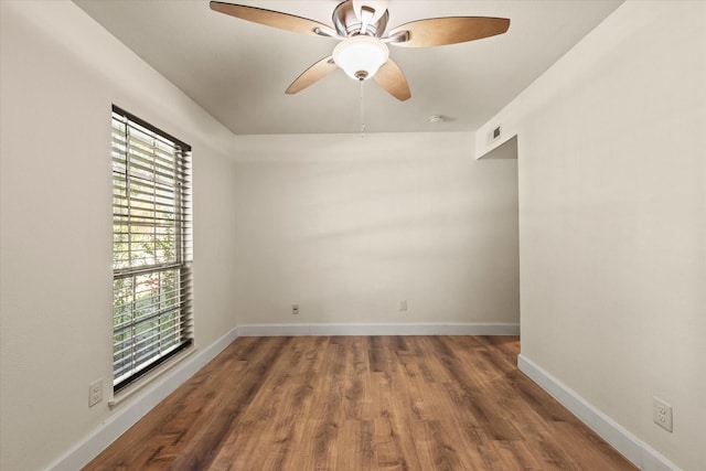 empty room with ceiling fan, dark wood-type flooring, and a wealth of natural light