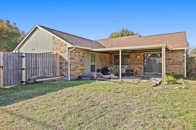 back of house featuring a patio and a lawn