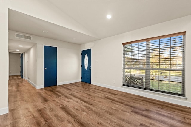 spare room with wood-type flooring and vaulted ceiling