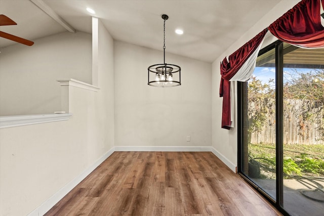 unfurnished dining area with hardwood / wood-style flooring, vaulted ceiling with beams, a healthy amount of sunlight, and a chandelier